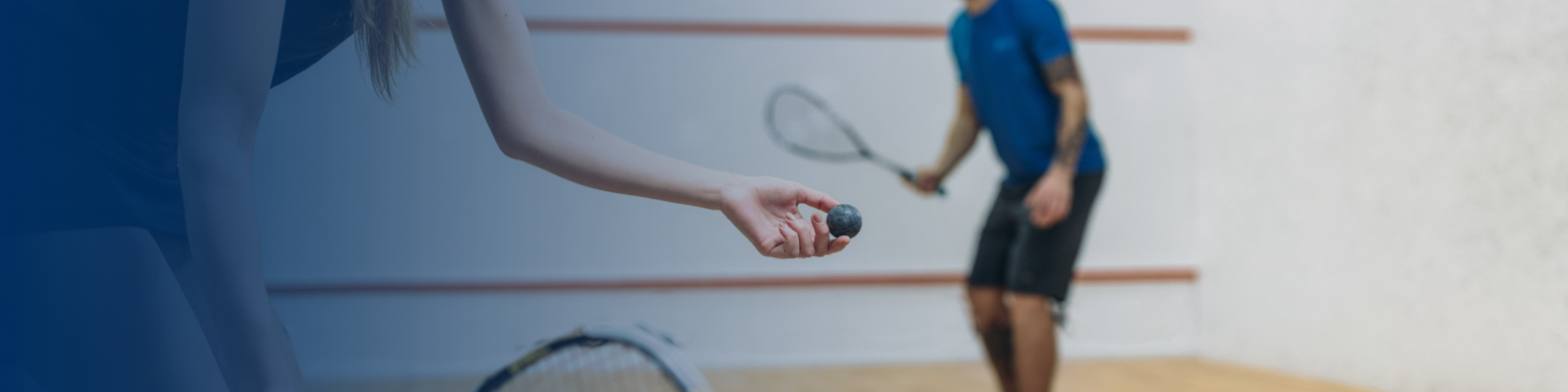 SQUASH - Image shows two players about to start a game of squash. The player to the left is holding the squash ball in her hand ready to serve.