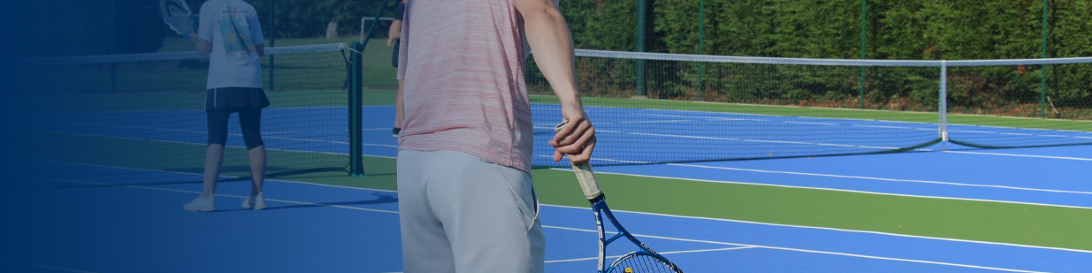 TENNIS - Image shows male player nearest the camera just about to serve, in the distance is a female player standing at the net ready to play.